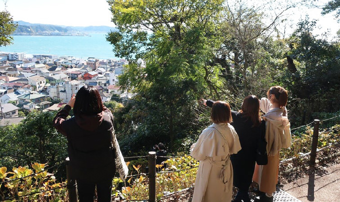 写真:丘から港町を見下ろす生徒